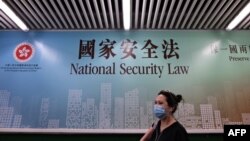 行人走过香港街头港版国安法的宣传牌。（2020年7月28日）