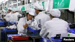 资料照片：中国广东东莞一家生产锂离子电池的工厂工人在生产线上。（2022年10月16日）