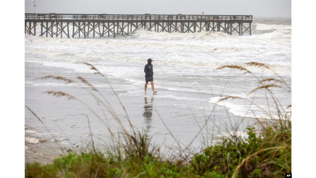 Jergen Wagner of Charleston, S.C., braves the wind and rain on the beach in Isle of Palms, S.C., as Tropical Storm Debby approaches, Aug. 6, 2024.