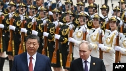 Президент Росії Володимир Путін і президент Китаю Сі Цзіньпін на офіційній церемонії зустрічі перед Народним залом на площі Тяньаньмень у Пекіні, 16 травня 2024 року. (Сергій Бобильов/Sputnik/viaAFP)