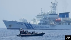 资料照片：在美国、日本和菲律宾三边海岸警卫队演习期间，一艘菲律宾海警的硬底橡皮艇经过日本海上保安厅的“秋津洲”号。（2023年6月6日）