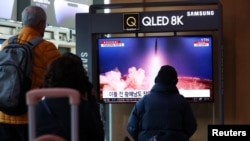 民众在韩国首尔一个火车站观看朝鲜发射洲际弹道导弹的电视新闻。（2023年3月16日）