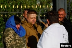 A priest sprays holy water on believers during the Orthodox Easter service in front of a church in the town of Kostiantynivka, amid Russia's attack on Ukraine, near a front line in Donetsk region, Ukraine, May 5, 2024.