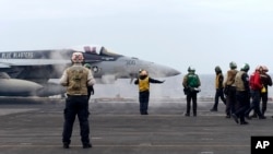 美日韩三国在东中国海举行联合海军军演期间，一架 F-18E 战斗机正准备从美国海军西奥多·罗斯福号航空母舰上起飞。(2024年4月11日)