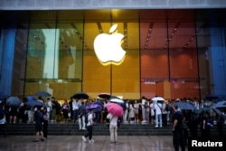 上海一家苹果专卖店外排队的人等候购买 iPhone 15 手机。（2023年6月15日）