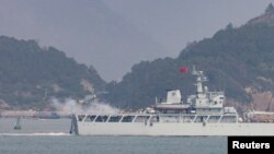 资料照片：在靠近台湾金门岛的福建省福州附近海域，一艘中国海军战舰在举行军演时开火。（2023年4月8日）
