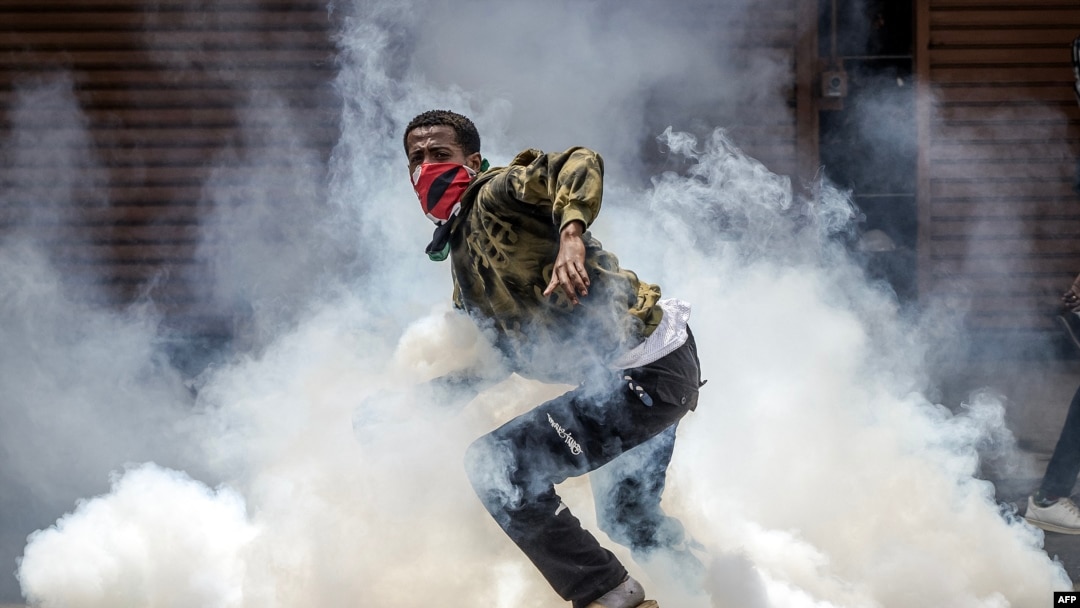 Mwandamanaji akitorokea gesi ya kutoa machozi, wakati wa maandamano ya Nairobi. 