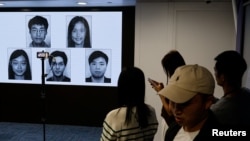 香港当局在记者会上公布被通缉的五名活动人士的照片。（2023年12月14日）