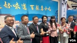 安徽省文旅厅副厅长王靖(左四)星期五(7月12日)参访台北国际夏季旅展暨海峡两岸旅展的摊位 (美国之音特约记者林乃绢拍摄)。