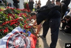 Архівни фото - Боєць ПВК "Вагнер" кладе кувалду, один із символів групи, до неофіційного меморіалу біля колишнього Центру ПВК "Вагнер" в Санкт-Петербурзі, Росія, 24 серпня 2023 року.