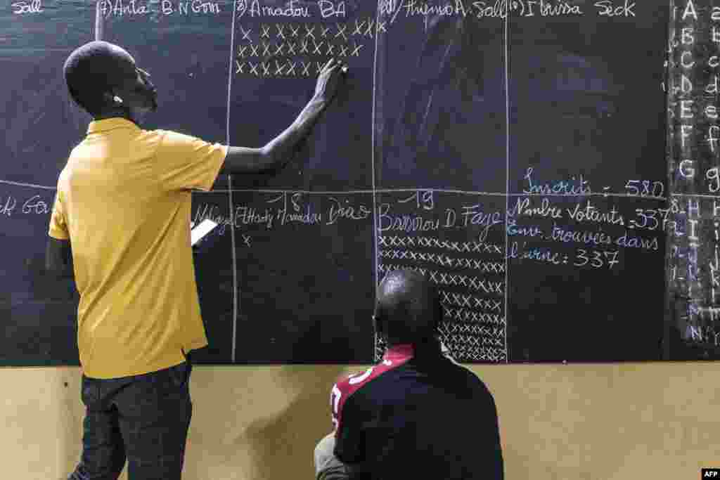 Um funcionário da mesa de voto faz a contagem dos boletins de voto em Ziguinchor, a 24 de março de 2024, durante as eleições presidenciais senegalesas.