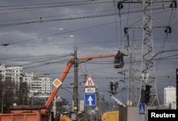 FILE - Energy supply workers restore a high-voltage line destroyed in Russian missile attack, amid Russia's attack on Ukraine, in Kyiv, Feb. 7, 2024.