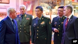 2023 年4月17日，中国国防部长李尚福将军（中）访问俄罗斯联军事学院时与院长弗拉基米尔·扎鲁德尼茨基将军（左）在一起。（美联社照片）