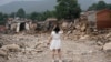 北京郊区一名女子在遭受洪水破坏的村子里无法找到自己家的房子。（2023年8月4日）