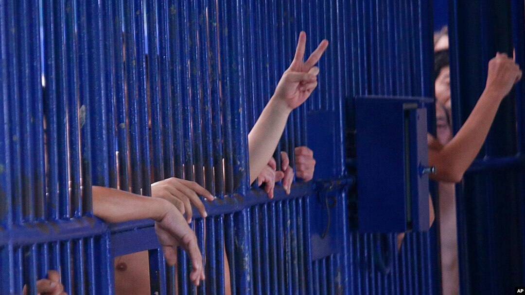 FILE - Detainees flash gestures at a Bangkok immigration detention center in Bangkok, Thailand, Jan. 21, 2019. According to the son of one former detainee, more than 50 adult Uyghur men remain in Thailand's immigration detention facilities. 