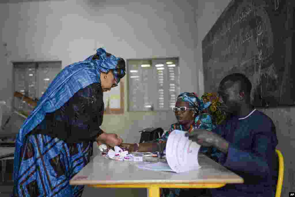 Eleitores esperam para votar à porta de uma assembleia de voto durante as eleições presidenciais, em Dakar, Senegal, no domingo, 24 de março de 2024.