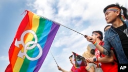 資料照 - 台灣LGBT和人權支持民眾2016年11月10 在台北的一個支持同性戀婚姻權利倡議的集會上揮舞彩虹旗。 2019年，台灣成為亞洲首個允許同性戀者結婚的國家。