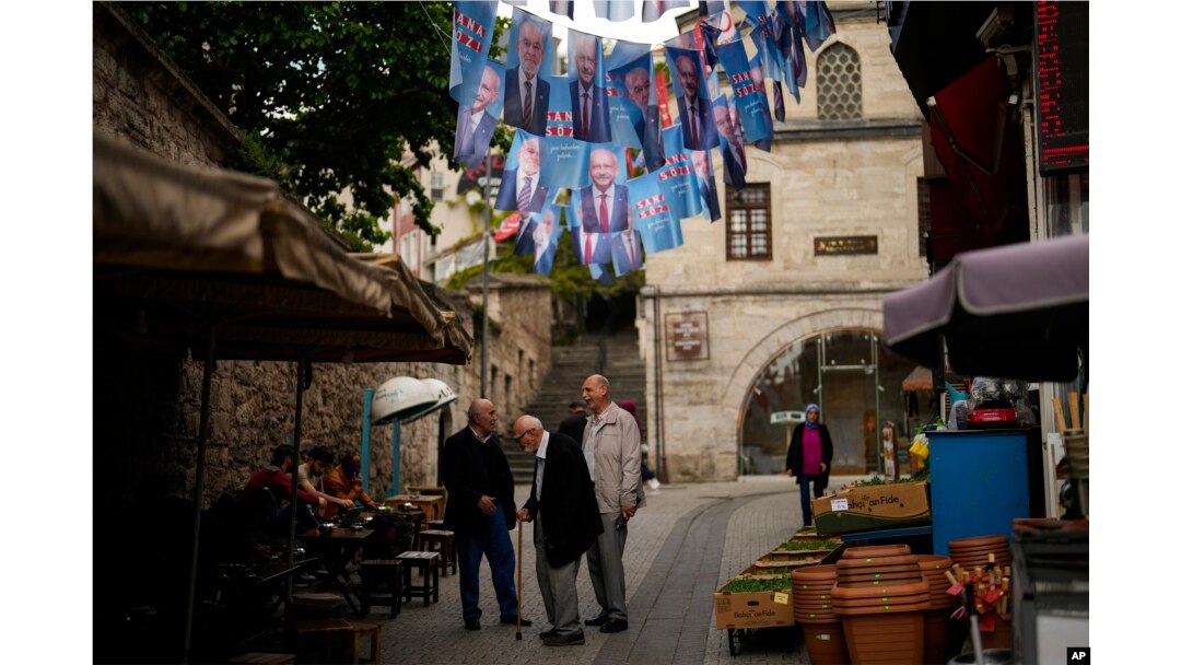 People talk under election banners of Turkish CHP party leader and Nation Alliance's presidential candidate Kemal Kilicdaroglu in Istanbul, Turkey, May 23, 2023.
