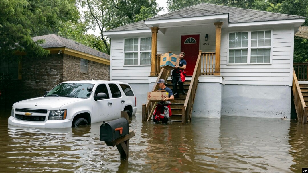 Savannah firefighters carry food to residents in the Tremont Park neighborhood that were stranded in stormwater from Tropical Storm Debby, Aug. 6, 2024, in Savannah, Ga.