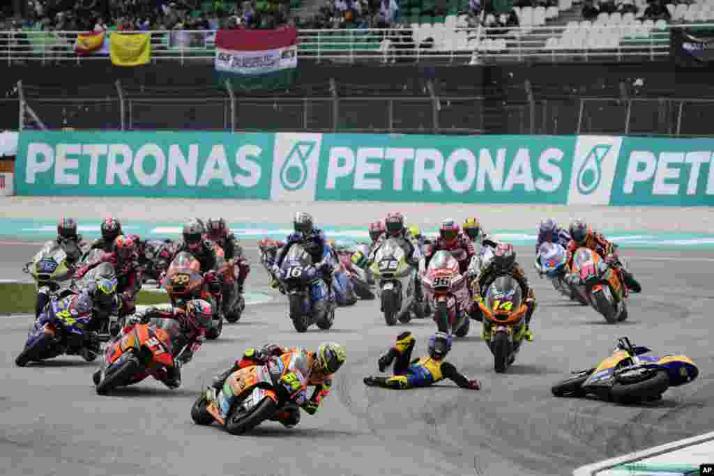 Spain&#39;s rider Fermin Aldeguer, foreground, leads as Spain&#39;s rider Manuel Gonzalez Simon falls during Moto2 class race of the MotoGP Malaysian Grand Prix at the Sepang International Circuit in Sepang, Malaysia.