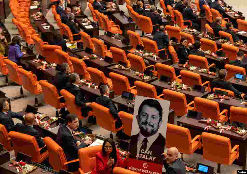 Erkan Bas, the leader of Workers' Party of Turkey (TIP), and his party MPs Sera Kadigil and Ahmet Sik display a portrait of Can Atalay, a jailed MP of TIP, during a swearing-in ceremony at the Turkish parliament in Ankara, Turkey. Atalay has not been released despite a law that opens a way for jailed politicians to be released from prison if they are elected to parliament.