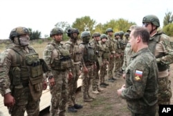 Заступник голови Ради безпеки Росії Дмитро Медведєв (спереду праворуч) спілкується з російськими військовими під час візиту на військовий полігон в окупованій Росією частині Донецької області України 15 вересня 2023 року. (Sputnik/через AP)