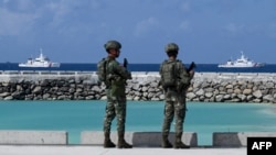 菲律賓士兵在南海有主權爭議的中業島上遙望菲律賓海岸警衛隊的船隻。 （2023年12月1日）