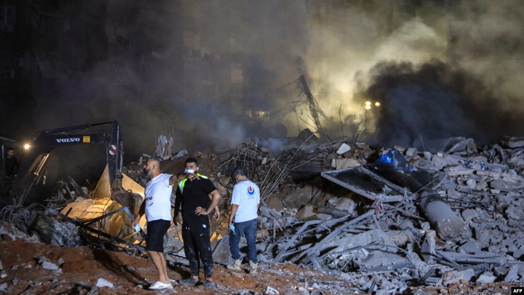 Spasioci pored ruševina zgrade u Bejrutu, uništene u izraelskom vazdušnom napadu (Foto: AFP)