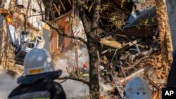 Фото: Пожежники працюють, після обстрілу дроном будівлі в Києві, 17 жовтня 2022 року