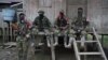 ARCHIVO - Integrantes del ELN de Colombia descansan afuera de una casa cerca del río San Juan, Colombia, en agosto de 2017.