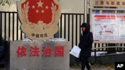 一名北京居民走过三里河街道普法宣传栏。（2021年11月8日）