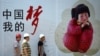 资料照：几名中国工人走过北京街头张贴的中国梦宣传画。（2013年9月2日）