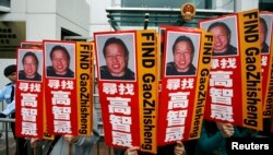 資料照：香港民眾在中聯辦前手舉多年失踪的中國著名維權律師高智晟的畫像與標語。 （2010年2月4日）