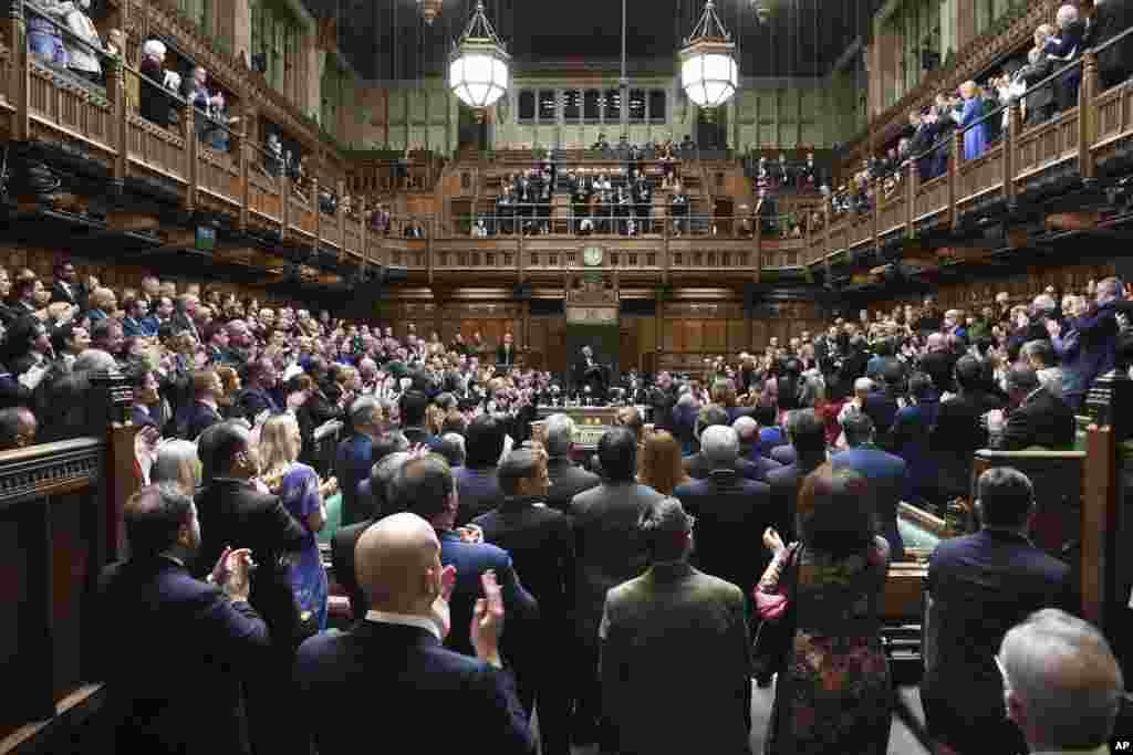 In this photo provided by UK Parliament, Ukraine’s ambassador to the United Kingdom Vadym Prystaiko, upper right balcony, stands in the public gallery during applause from British lawmakers in the House of Commons, London.