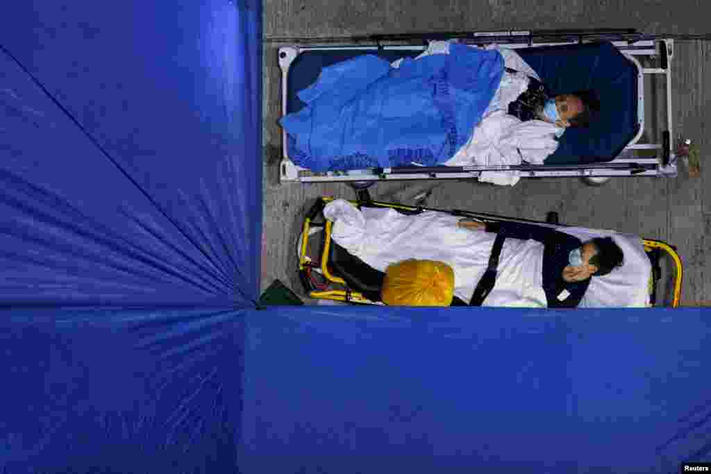 Patients sleep at a makeshift COVID-19 treatment area, outside a hospital in Hong Kong, March 1, 2022.