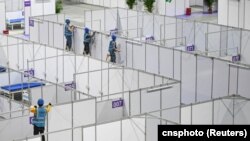 中國廣東廣州的工人在琶洲國際會展中心為新冠疫情修建方艙。（2022年4月10日）