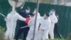 中国河南郑州富士康代工厂里身穿防护服的警察和保安殴打参加示威活动的工人。(2022年11月23日)