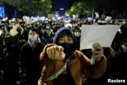 北京民众走上街头举起白纸游行抗议当局严厉的防疫封控措施。（2022年11月27日）