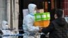 A delivery man delivers an order outside of a locked-down neighborhood after the detection of new cases of COVID-19 in Huangpu district, in Shanghai, on March 15, 2022.