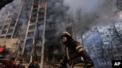 2022年3月15日乌克兰首都基辅一名消防人员在遭到炮火摧毁的一栋公寓楼前