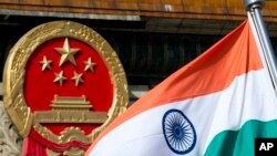 在北京人民大会堂外为来访的印度官员举行的欢迎仪式上，一面印度国旗在中国国徽旁飘扬（2013年10月23日）。