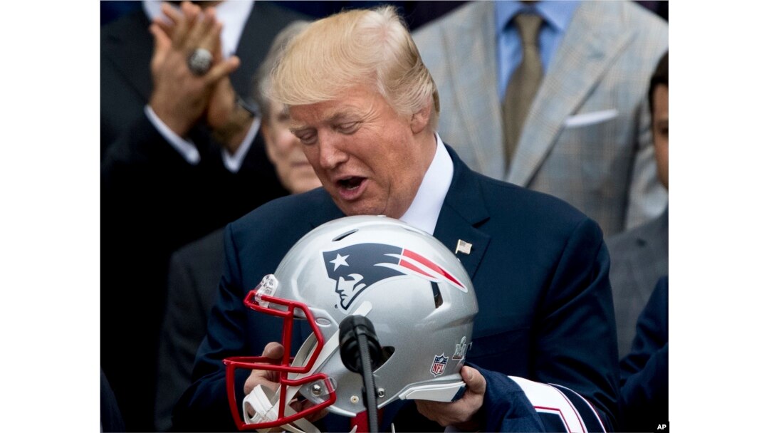 President Donald Trump is presented with a New England Patriots football helmet and jersey by Patriots coach Bill Belichick and Patriots owner Robert Kraft during a ceremony on the South Lawn of the White House in Washington, April 19, 2017.