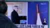 在韩国首尔火车站，有人观看电视新闻显示的朝鲜报纸刊登的照片，图片上有朝鲜领导人金正恩和朝鲜发射导弹的景象（2017年2月13日）