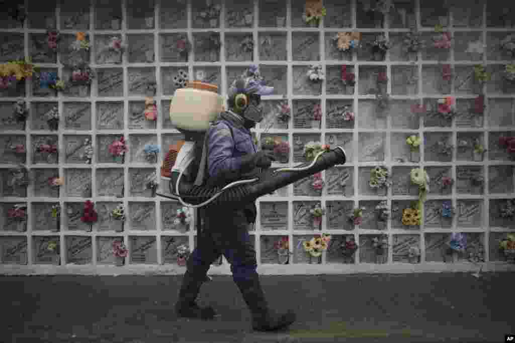 A cemetery worker sprays disinfect at niches inside Nuestra Señora de Belen cemetery amid the COVID-19 pandemic in Fusagasuga, Colombia.