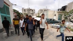 巴勒斯坦人在加沙拉法城的西北地区将一名在以军攻击中死亡的人下葬。(6月22日)