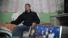 中国著名维权律师高智晟2015年在陕西的窑洞住宅里听记者讲话，旁边是他儿子的照片和女儿与美国前总统布什的合影
