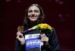 In this Tuesday, Oct. 1, 2019 file photo, Gold medalist Mariya Lasitskene, who participates as a neutral athlete, poses during the medal ceremony for the women's high jump at the World Athletics Championships in Doha, Qatar.