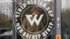 FILE - A man wearing a camouflage uniform walks out of PMC Wagner Center during the official opening of the office block in Saint Petersburg, Russia, Nov. 4, 2022.