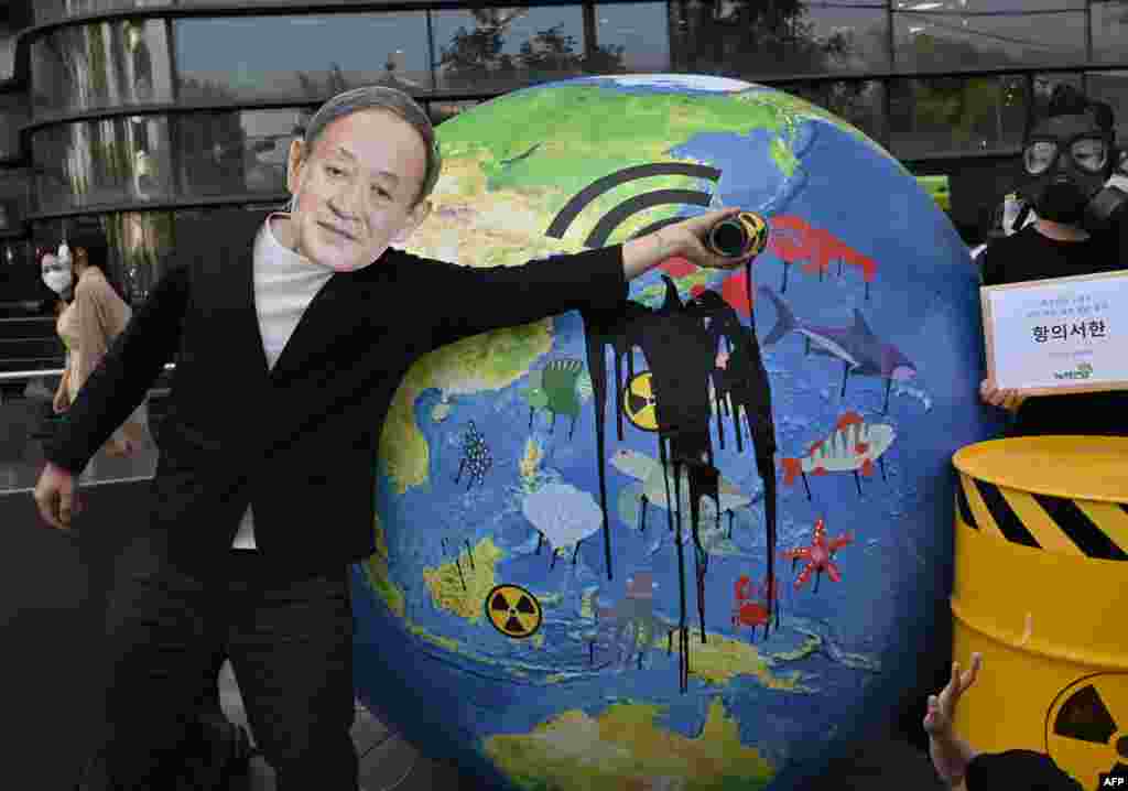 A South Korean environmental activist wearing a mask of Japan's Prime Minister Yoshihide Suga performs during a protest against Japan's decision to discharge Fukushima wastewater into the sea, near the Japanese embassy in Seoul.