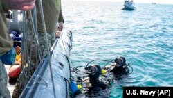 美国海军提供的照片显示美军潜水员在南卡罗莱纳州海岸外打捞被击落的中国间谍气球碎片。（2023年2月7日）